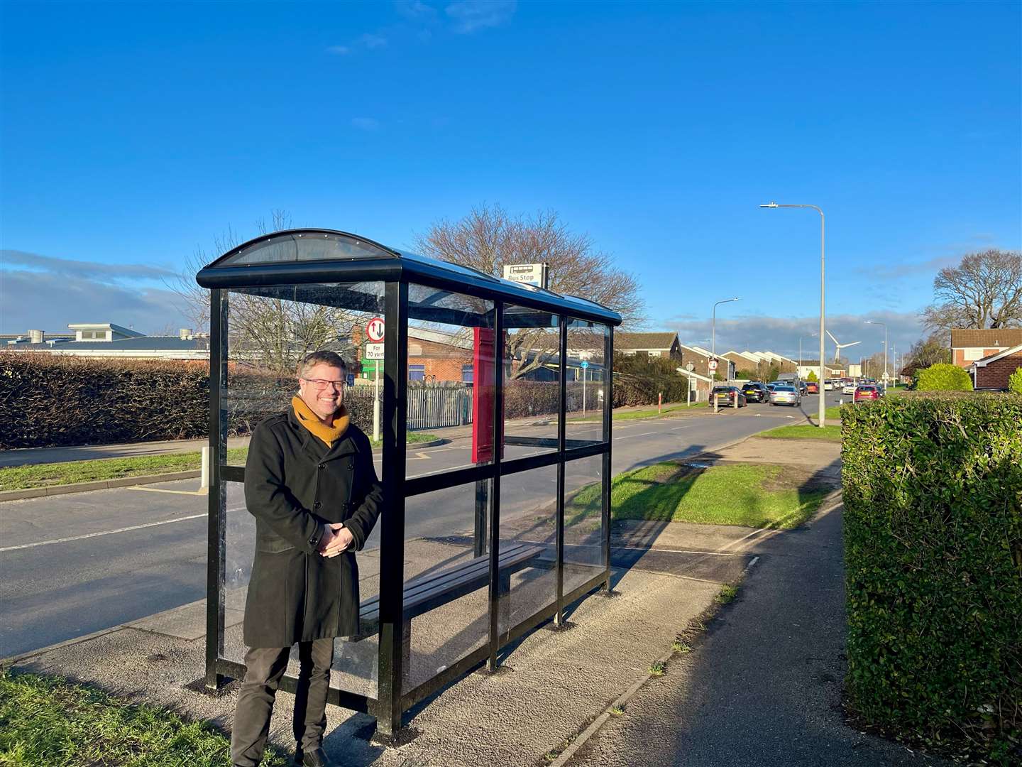 Cllr Rob Colwell at the bus shelter at Churchill Park Academy, which was installed in December